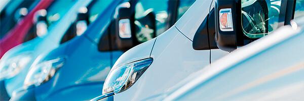 Seguro del Automovil para Empresas - Flota de furgonetas de empresa de diferentes colores aparcadas juntas entre ellas Seguro del Automovil para Empresas - Flota de furgonetas de empresa de diferentes colores aparcadas juntas entre ellas